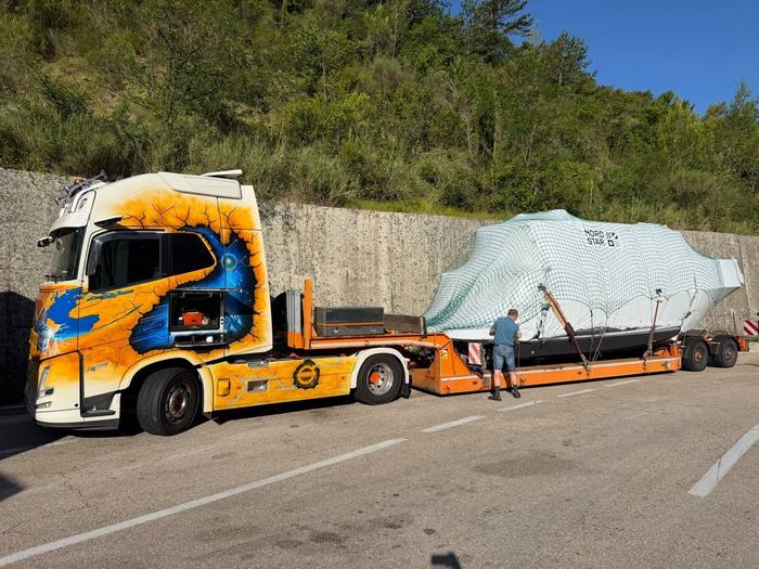 Wrapped boat loaded on a low-bed trailer for road transport