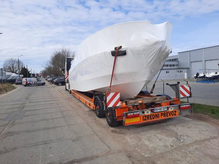 Truck transporting a shrink-wrapped boat through Montenegro